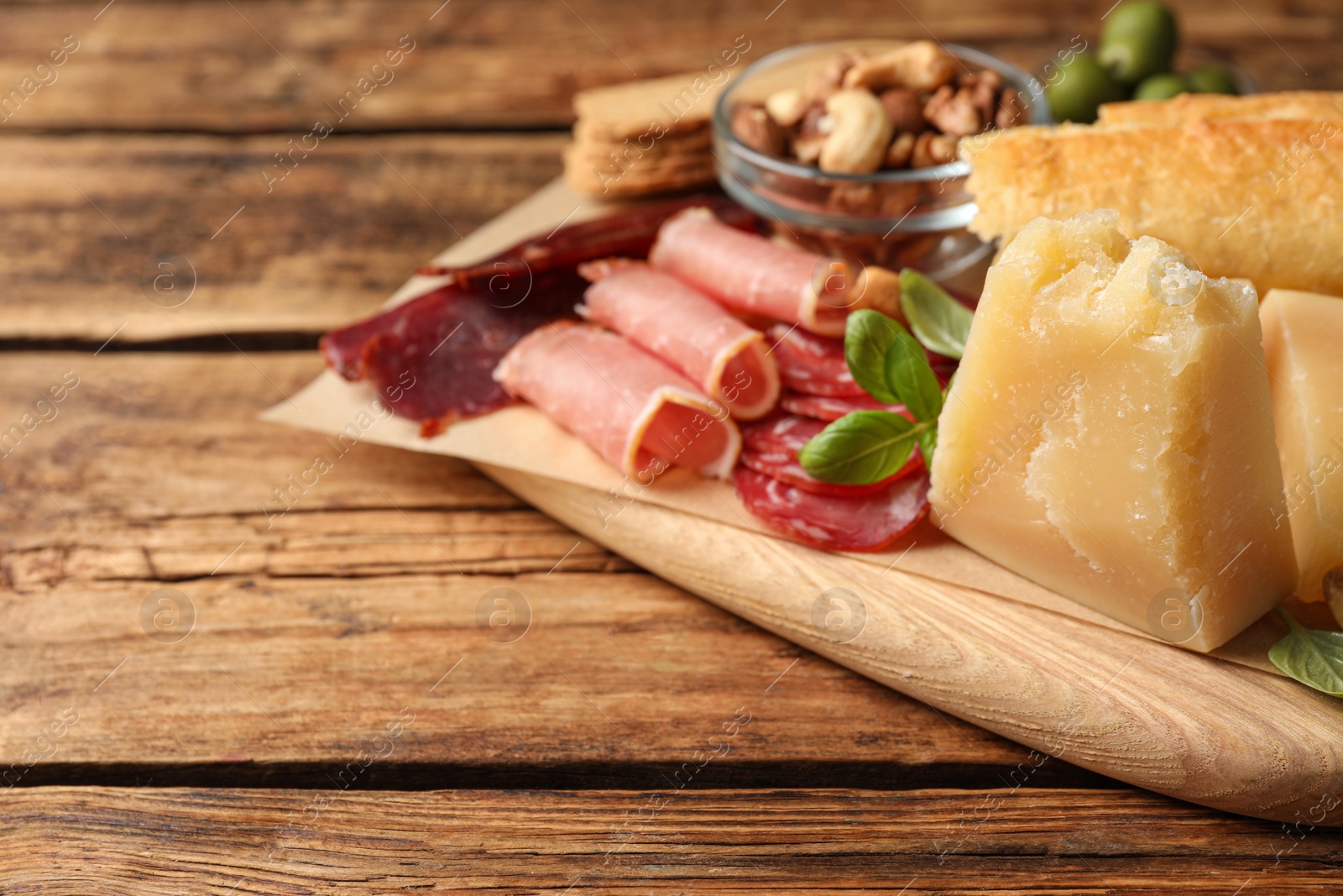 Photo of Snack platter with parmesan cheese served on wooden table, closeup