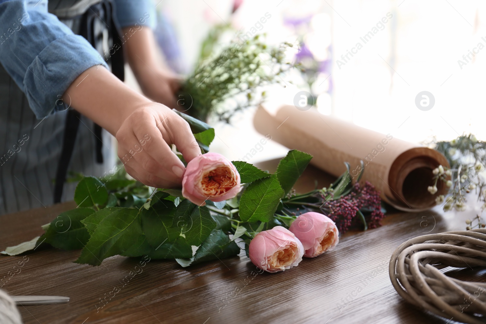 Photo of Female florist creating beautiful bouquet at table