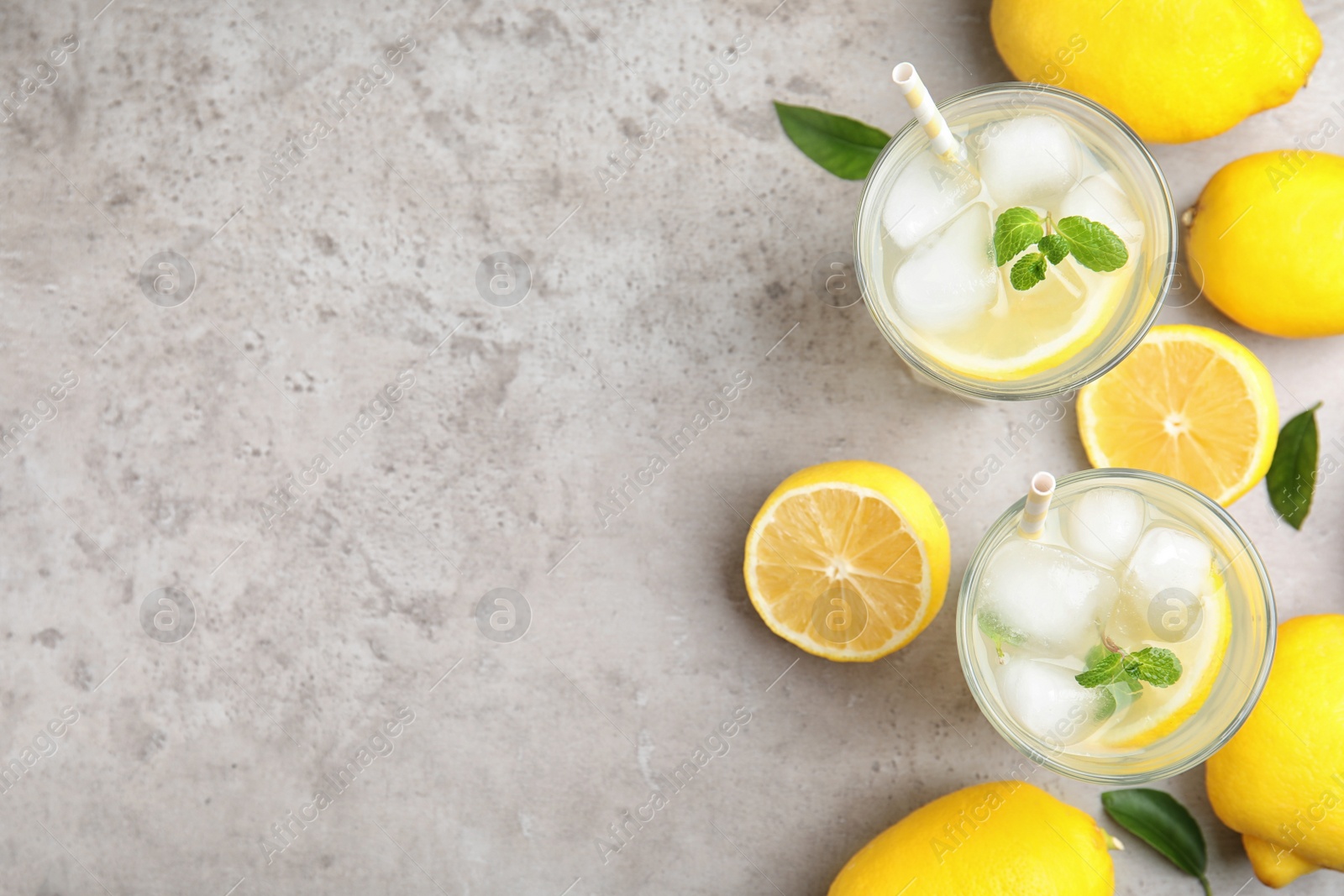 Photo of Cool freshly made lemonade and fruits on grey table, flat lay. Space for text