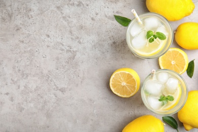 Cool freshly made lemonade and fruits on grey table, flat lay. Space for text