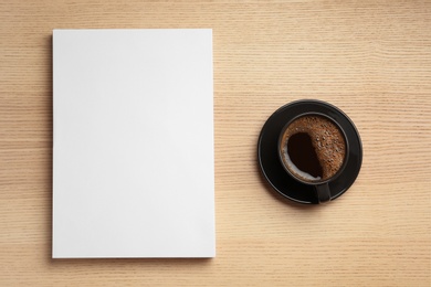 Blank paper sheets for brochure and cup of coffee on wooden background, flat lay. Mock up