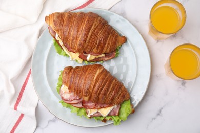 Photo of Tasty croissants with brie cheese, ham and bacon on white marble table, flat lay