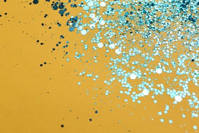Shiny bright light blue glitter on yellow background. Space for text