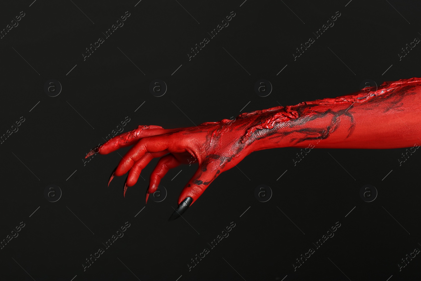 Photo of Scary monster on black background, closeup of hand. Halloween character