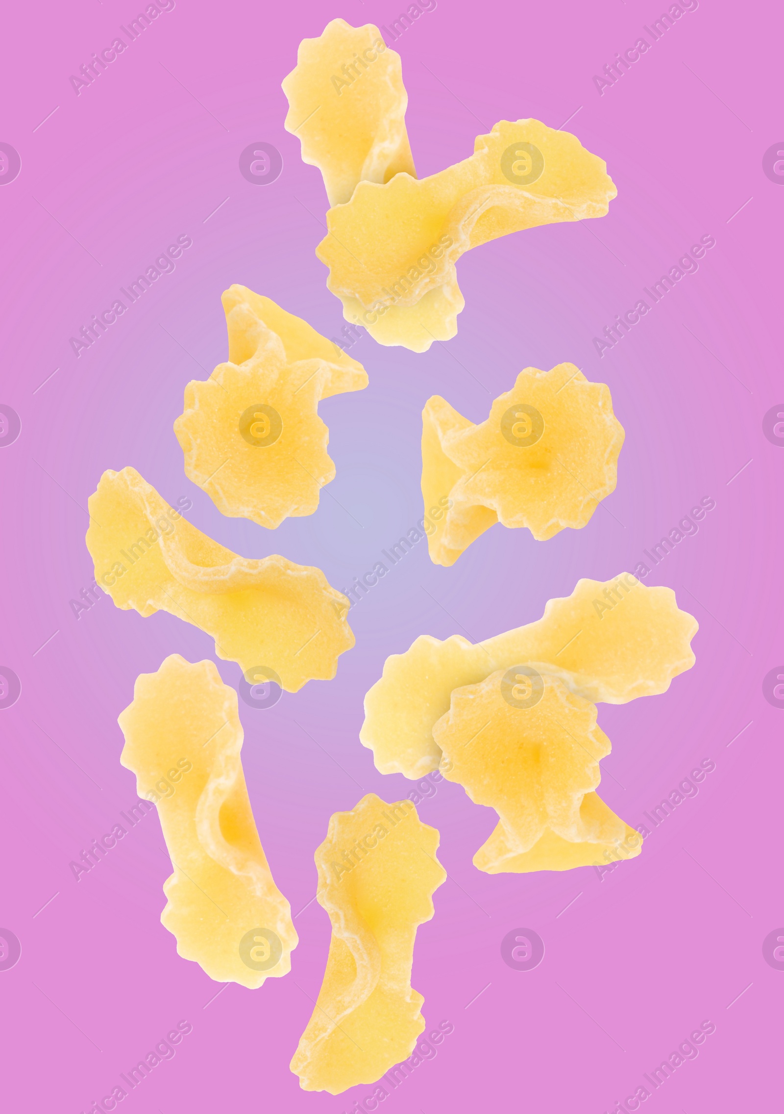 Image of Raw farfalline pasta falling on color background