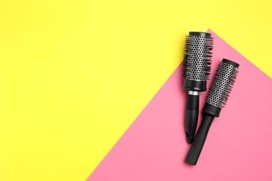 Photo of Round hair brushes on color background, flat lay. Space for text