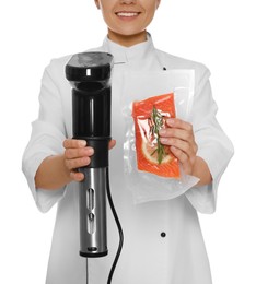 Photo of Chef holding sous vide cooker and salmon in vacuum pack on white background, closeup