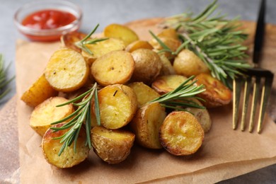 Photo of Tasty baked potato and aromatic rosemary served on board, closeup