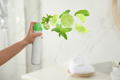 Image of Woman spraying air freshener in bathroom, closeup. Lime and minty aroma