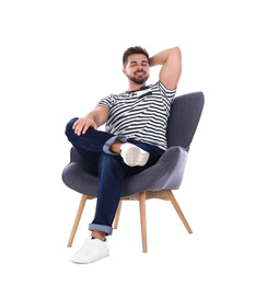 Photo of Young man sitting in armchair isolated on white