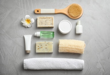 Photo of Flat lay composition with spa cosmetics and towel on grey background
