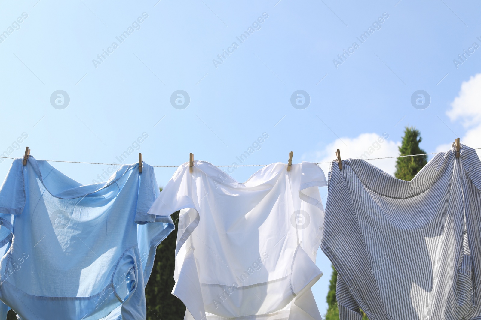 Photo of Clean clothes hanging on washing line outdoors. Drying laundry