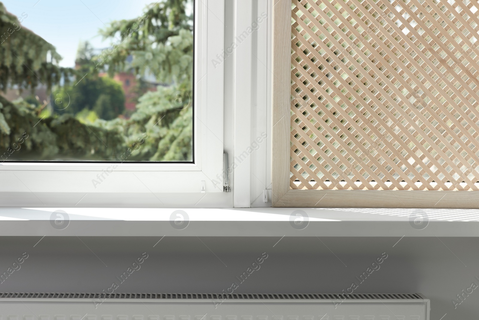 Photo of Empty white window sill and decorative wooden shutter indoors