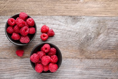 Photo of Tasty ripe raspberries on wooden table, flat lay. Space for text
