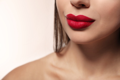 Woman with red lipstick on light background, closeup