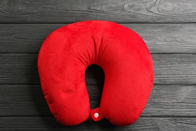 Image of Red travel pillow on wooden background, top view