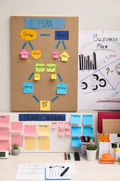 Photo of Business process planning and optimization. Workplace with colorful paper notes and other stationery on white wooden table