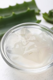 Photo of Aloe vera gel in bowl on white background, closeup