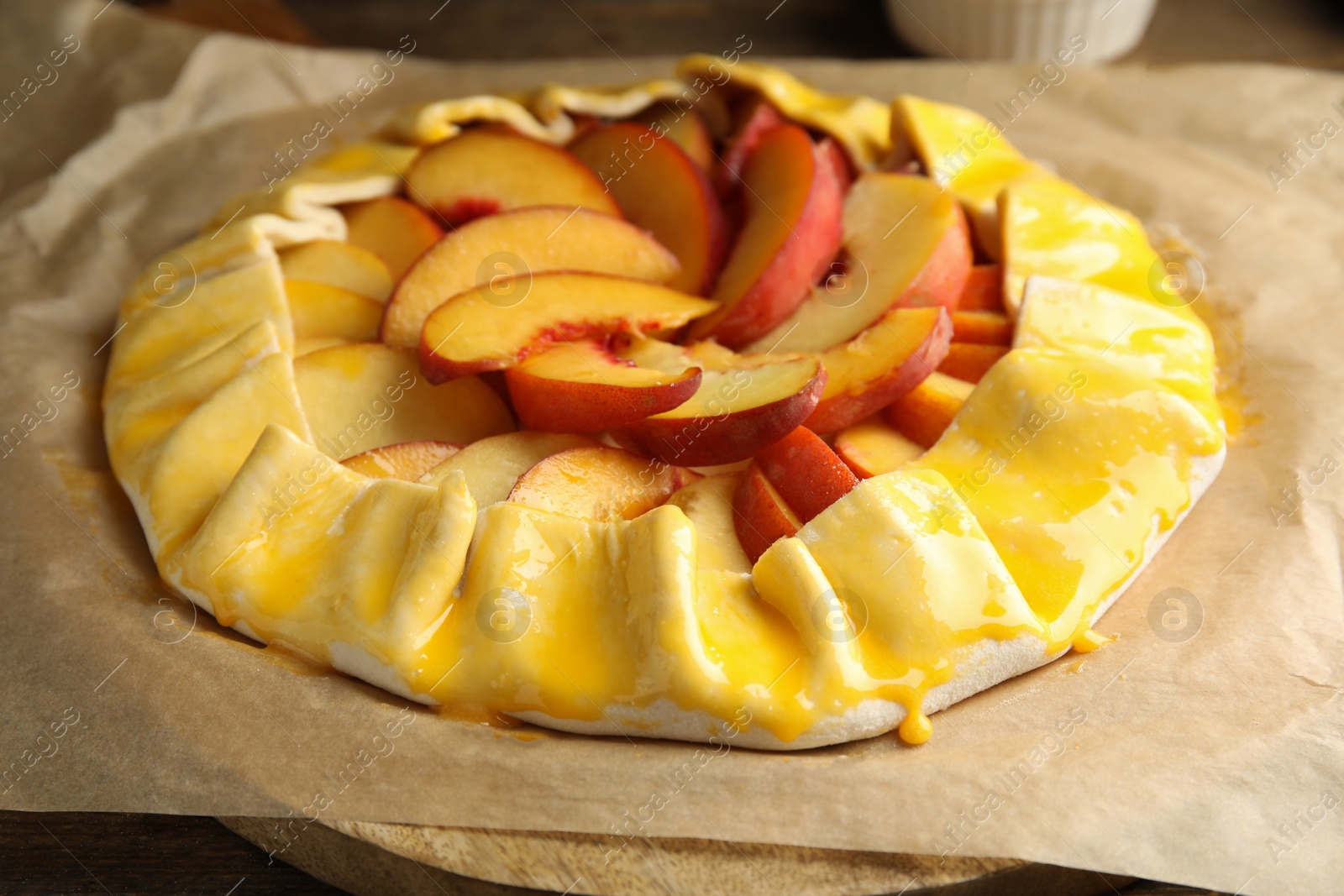 Photo of Uncooked peach pie on wooden table, closeup