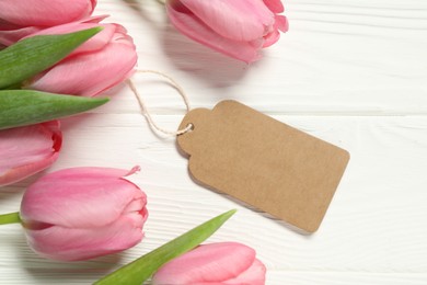 Happy Mother's Day. Beautiful tulips with blank card on white wooden table, flat lay