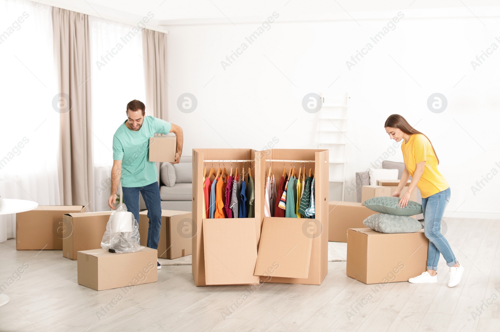 Photo of Young couple near wardrobe boxes at home