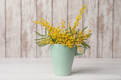 Photo of Bouquet of beautiful mimosa flowers on white wooden table