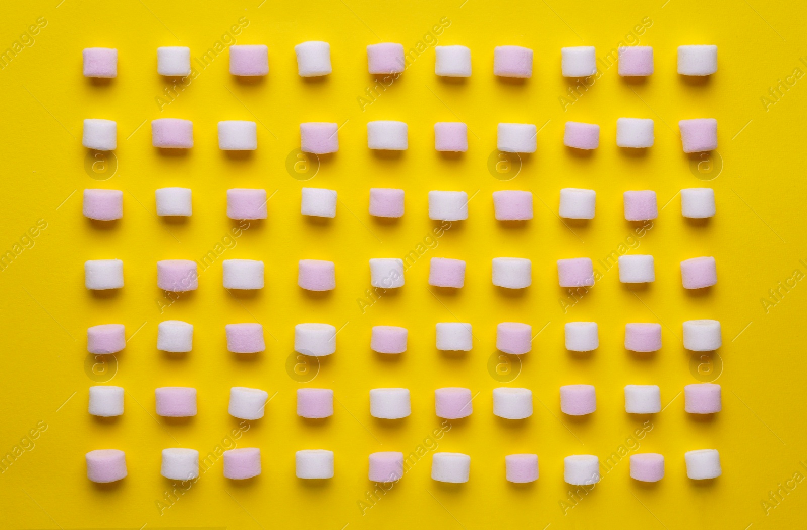 Photo of Delicious marshmallows on yellow background, flat lay