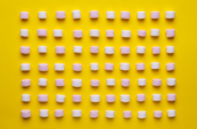 Photo of Delicious marshmallows on yellow background, flat lay