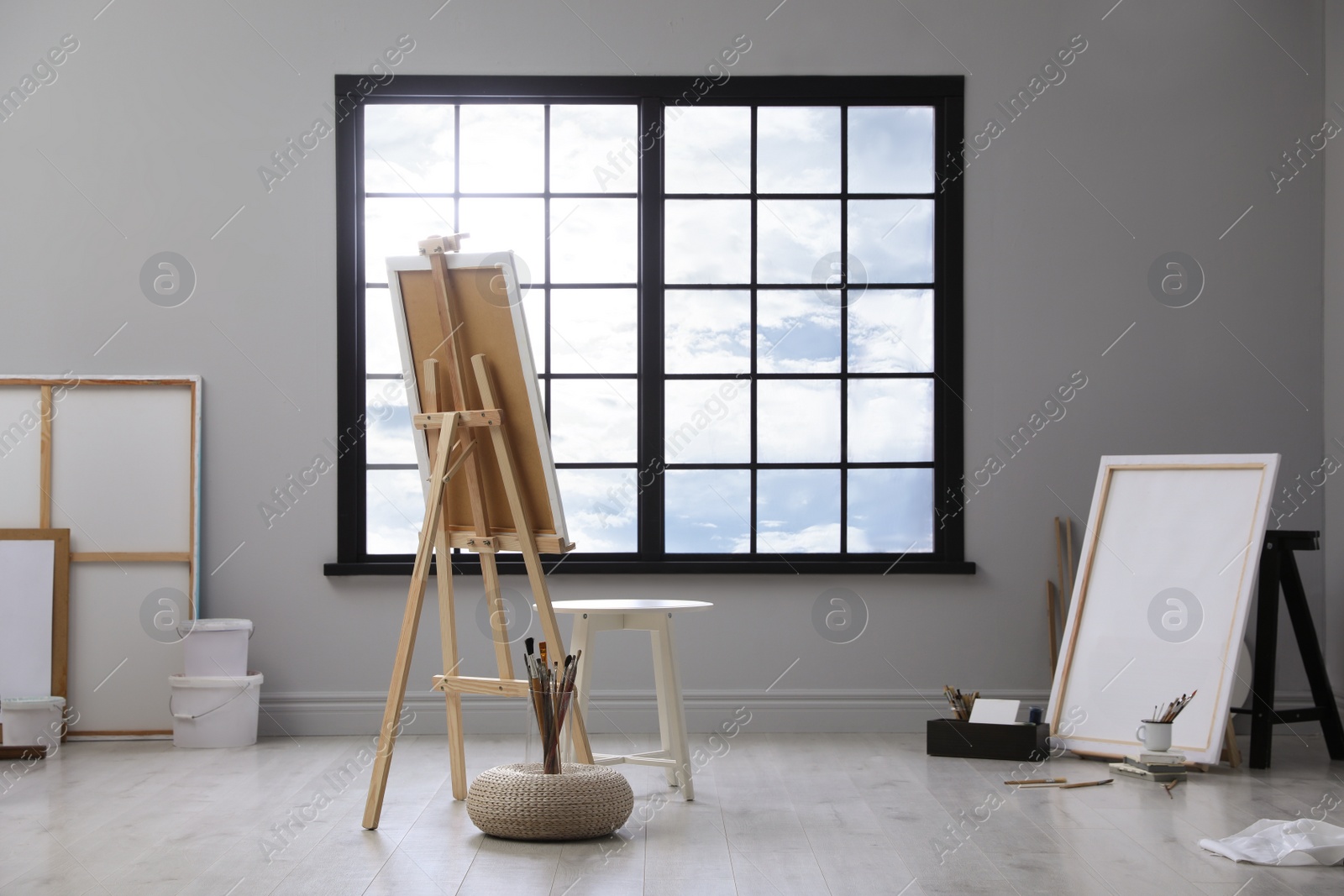 Photo of Stylish artist's studio interior with easel and brushes