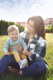 Happy mother with her cute baby at backyard on sunny day