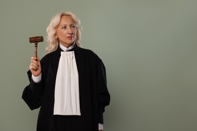 Photo of Senior judge with gavel on green background. Space for text
