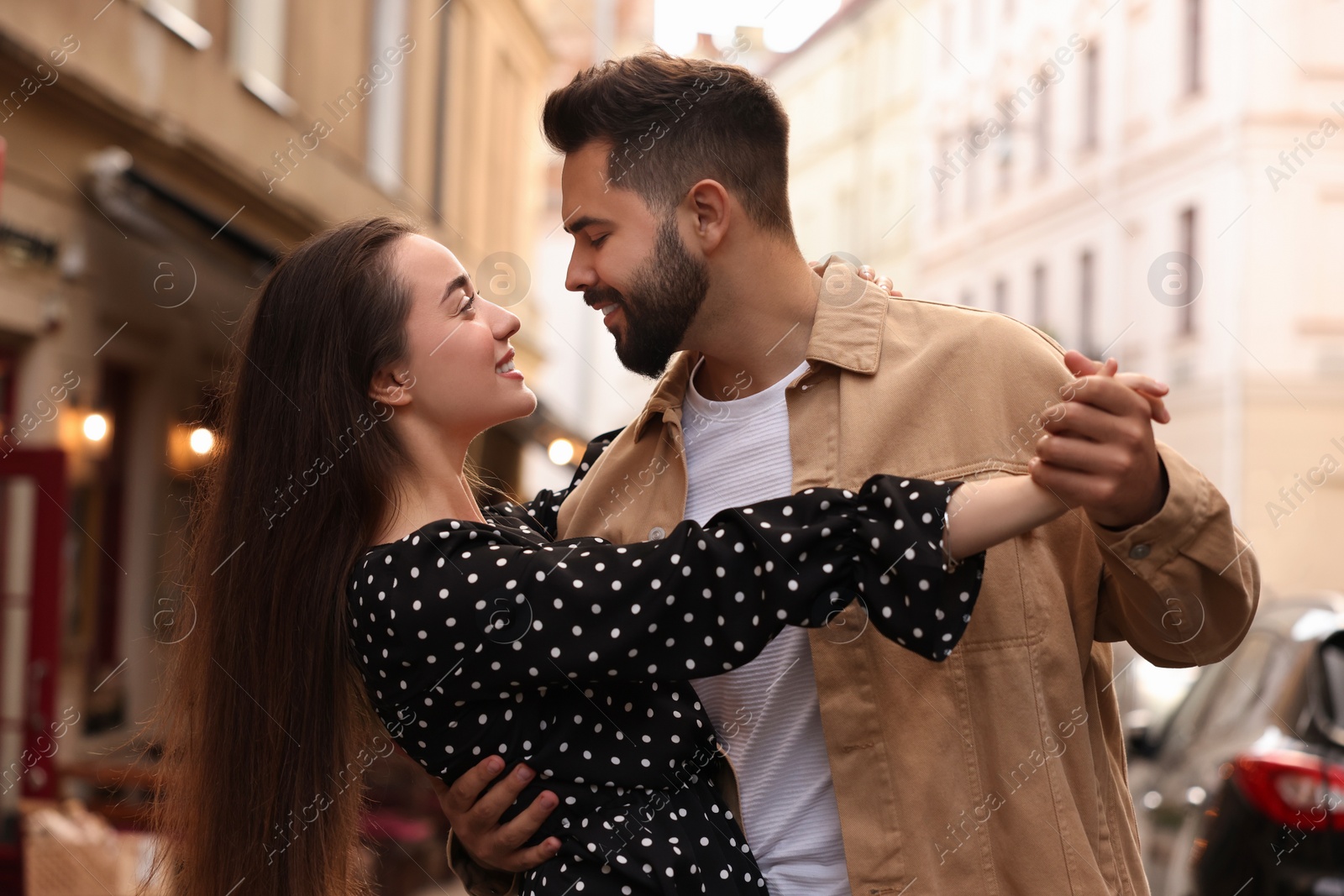 Photo of Lovely couple dancing together on city street