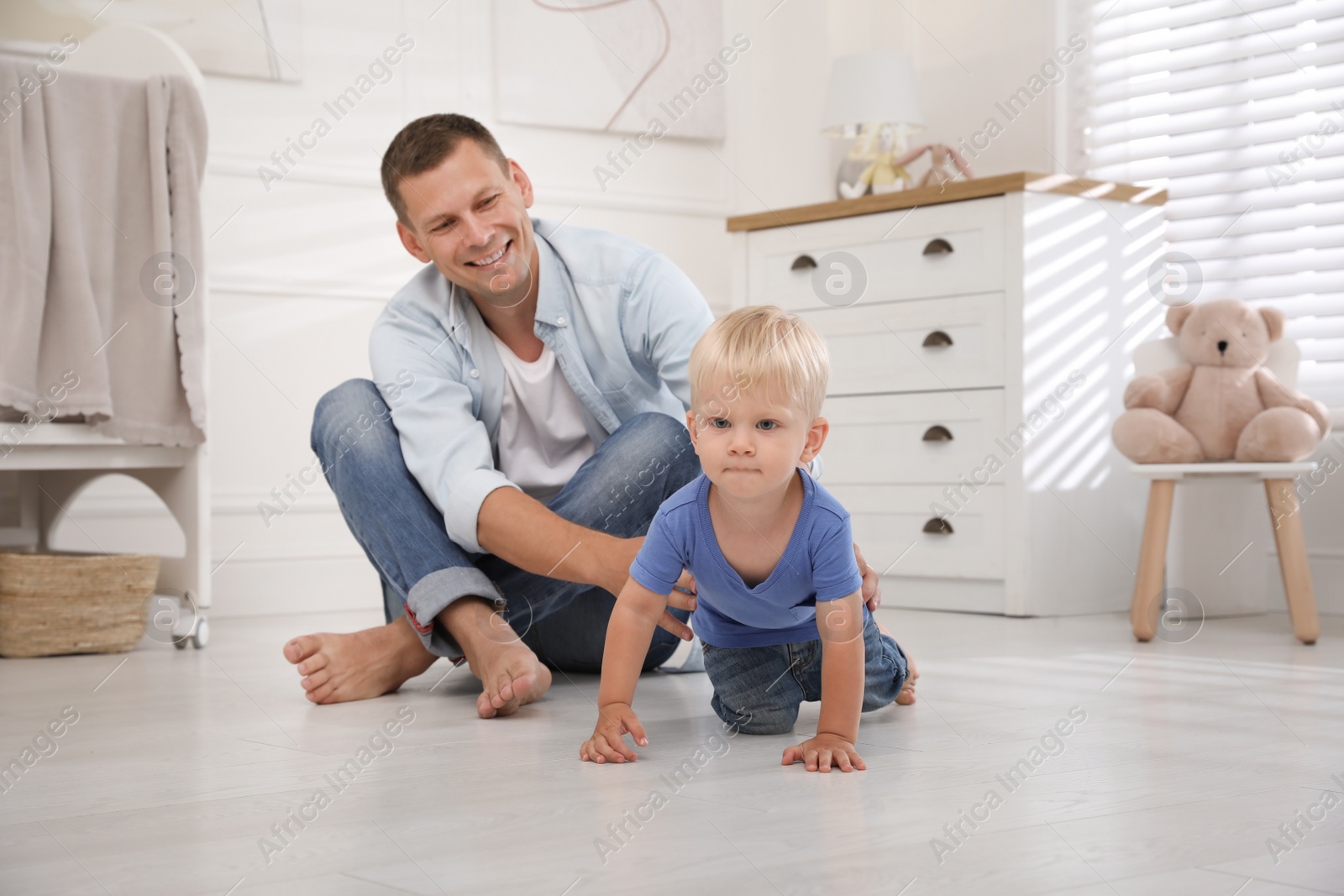 Photo of Father with his cute little son in nursery