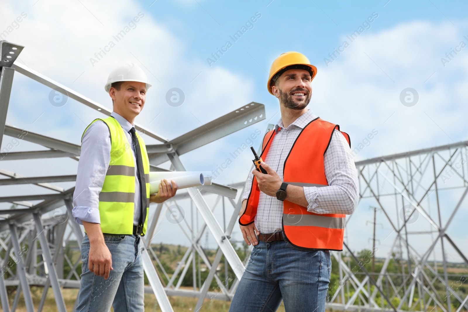 Photo of Professional engineers working on installation of electrical substation outdoors