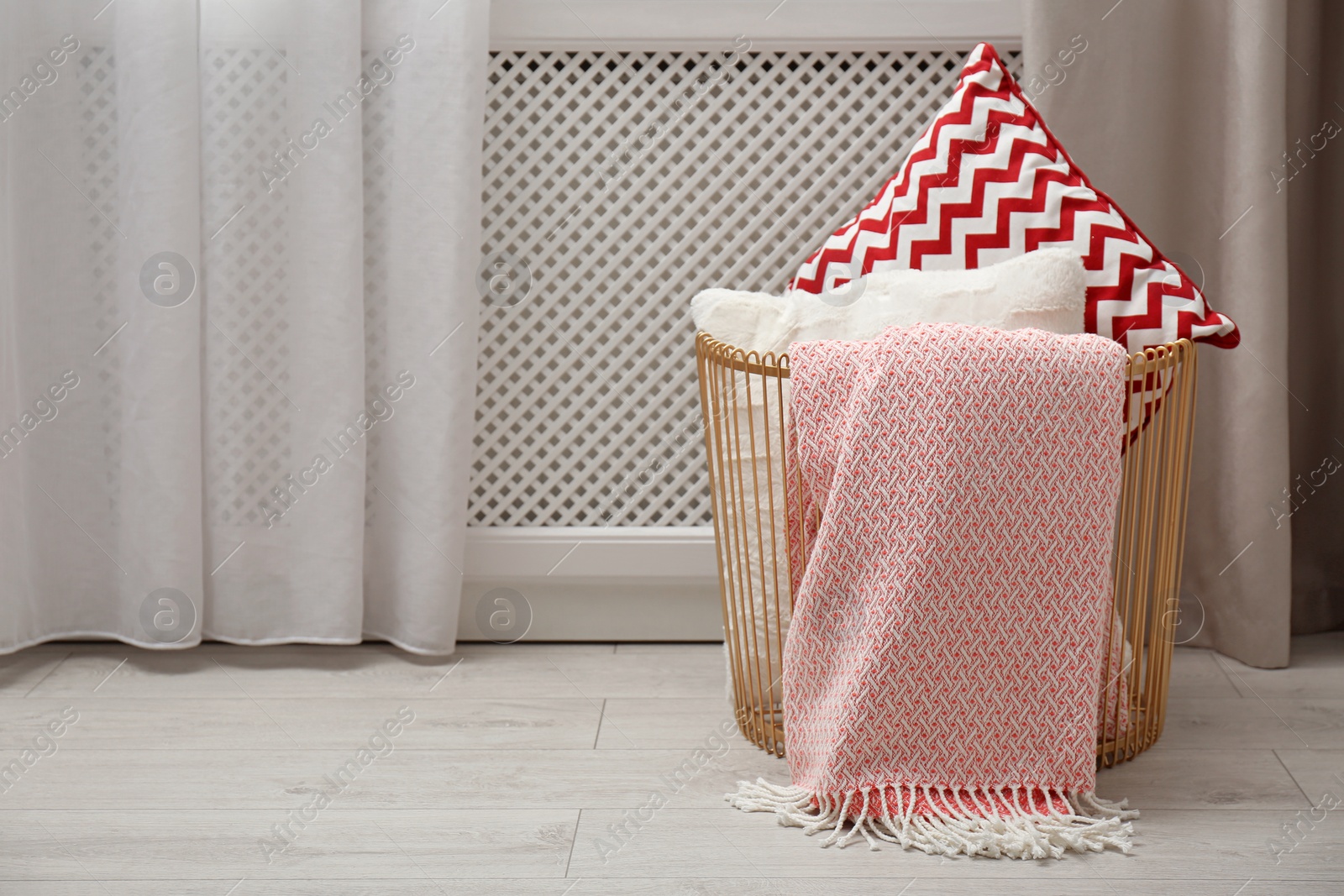 Photo of Basket with pillows and plaid in modern room