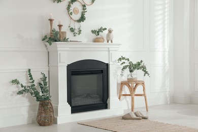 Stylish room with beautiful fireplace and eucalyptus branches