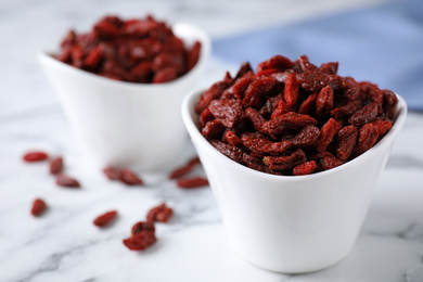 Photo of Dry goji berries on marble table, closeup