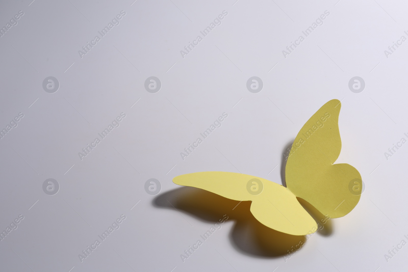 Photo of Yellow paper butterfly on light background. Space for text