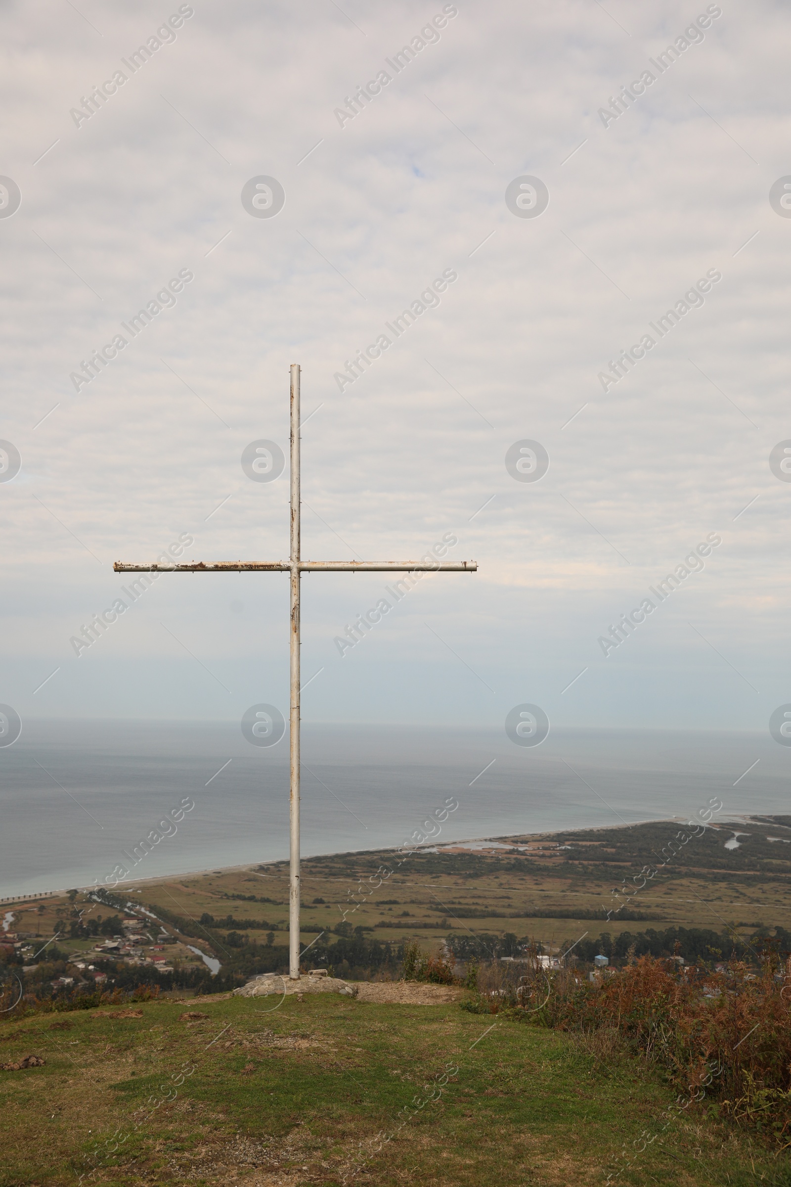 Photo of Picturesque view of beautiful sea and old cross under cloudy sky