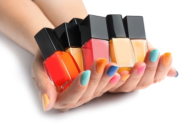 Photo of Woman holding bottles of nail polish on white background, closeup