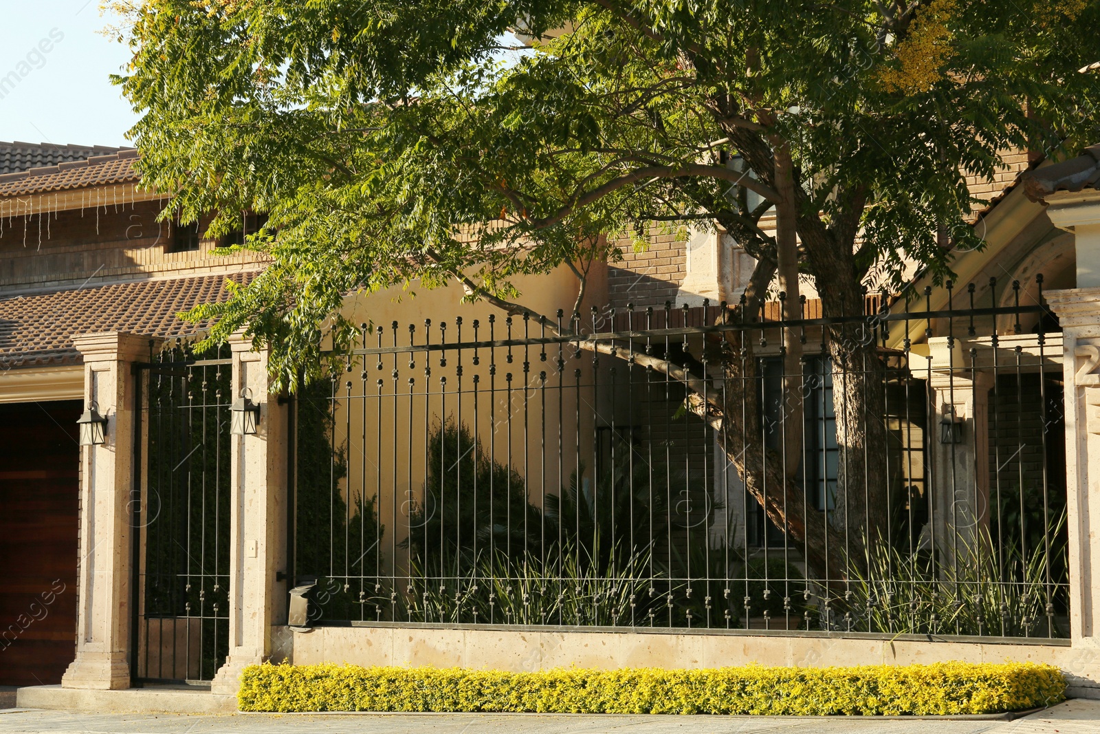 Photo of Closed metal door and fence outdoors on summer day