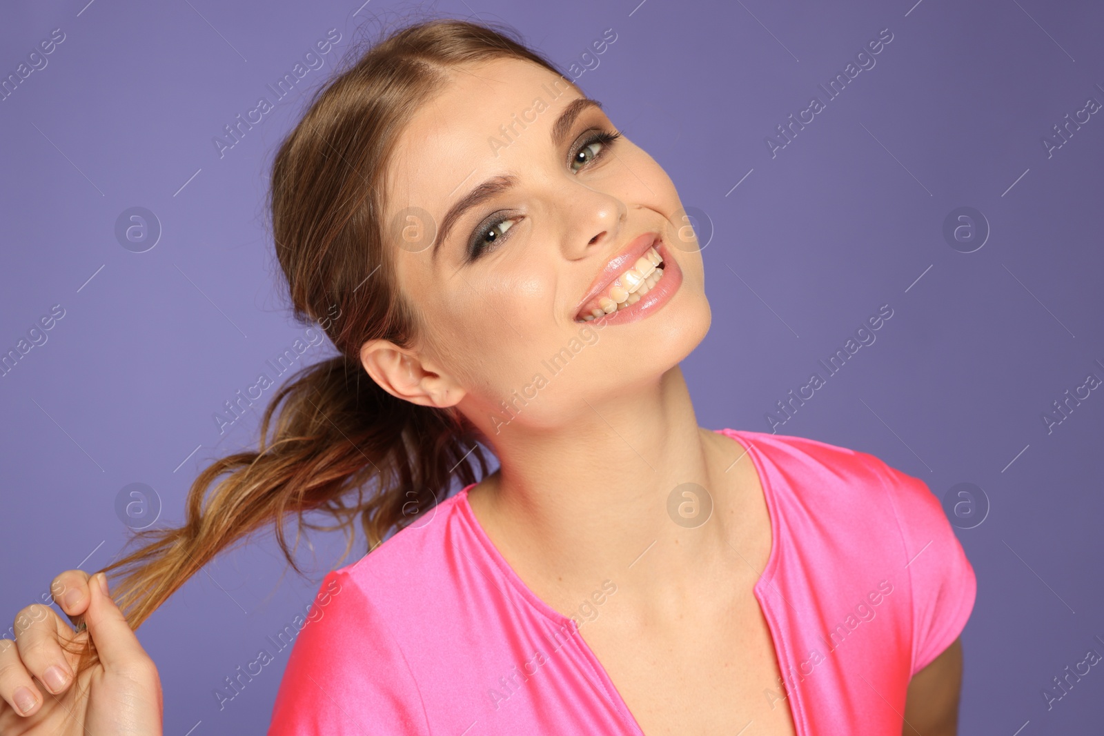 Photo of Portrait of young woman with beautiful makeup on violet background