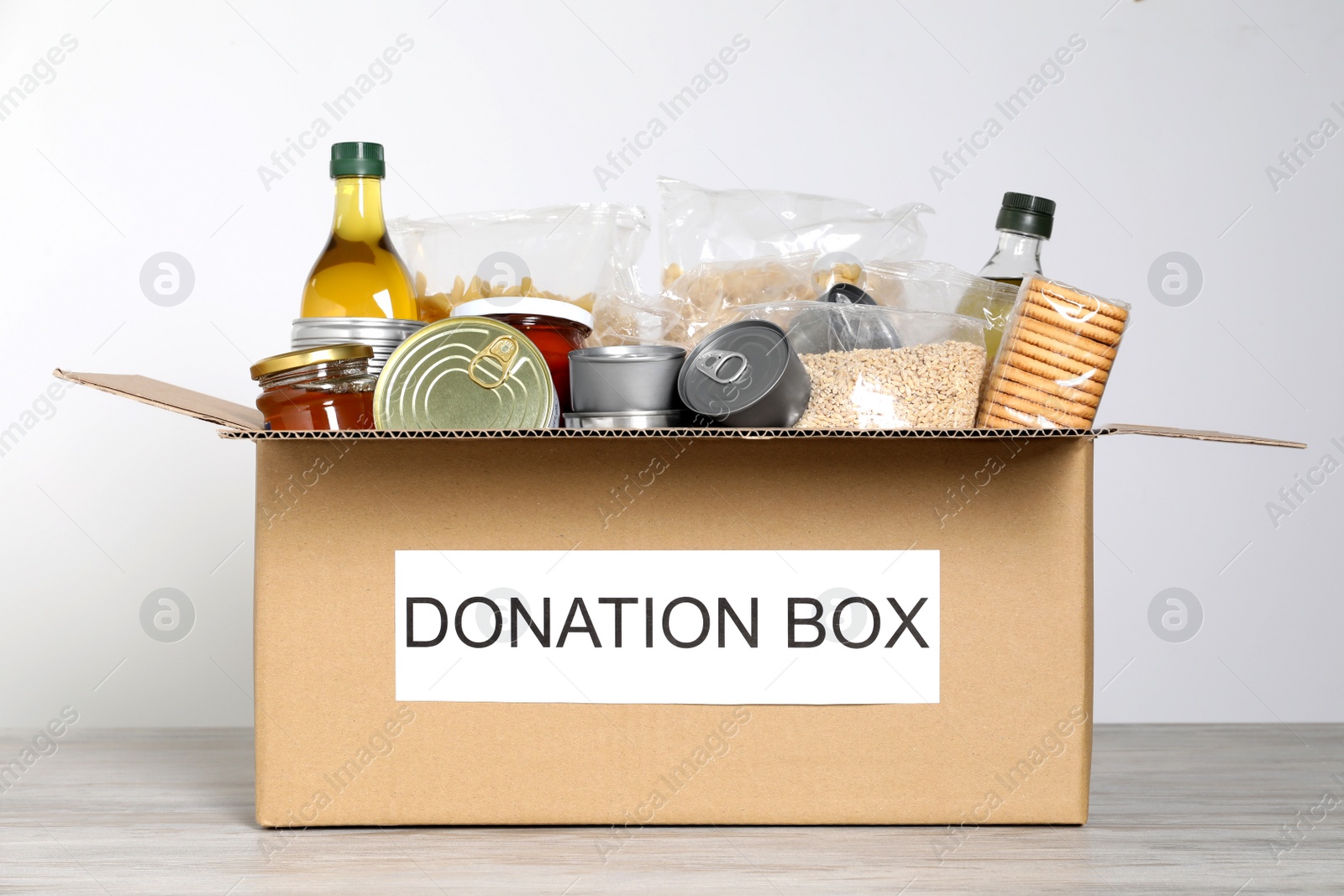 Photo of Donation box with food on wooden table
