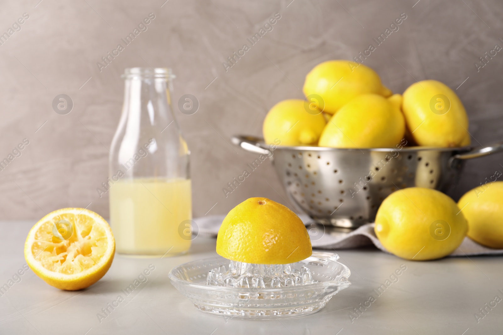 Photo of Composition with glass squeezer and lemons on table