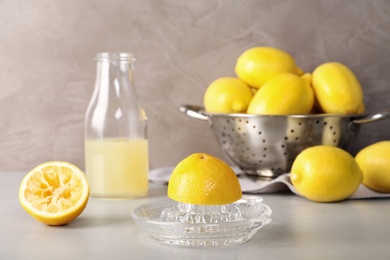 Composition with glass squeezer and lemons on table