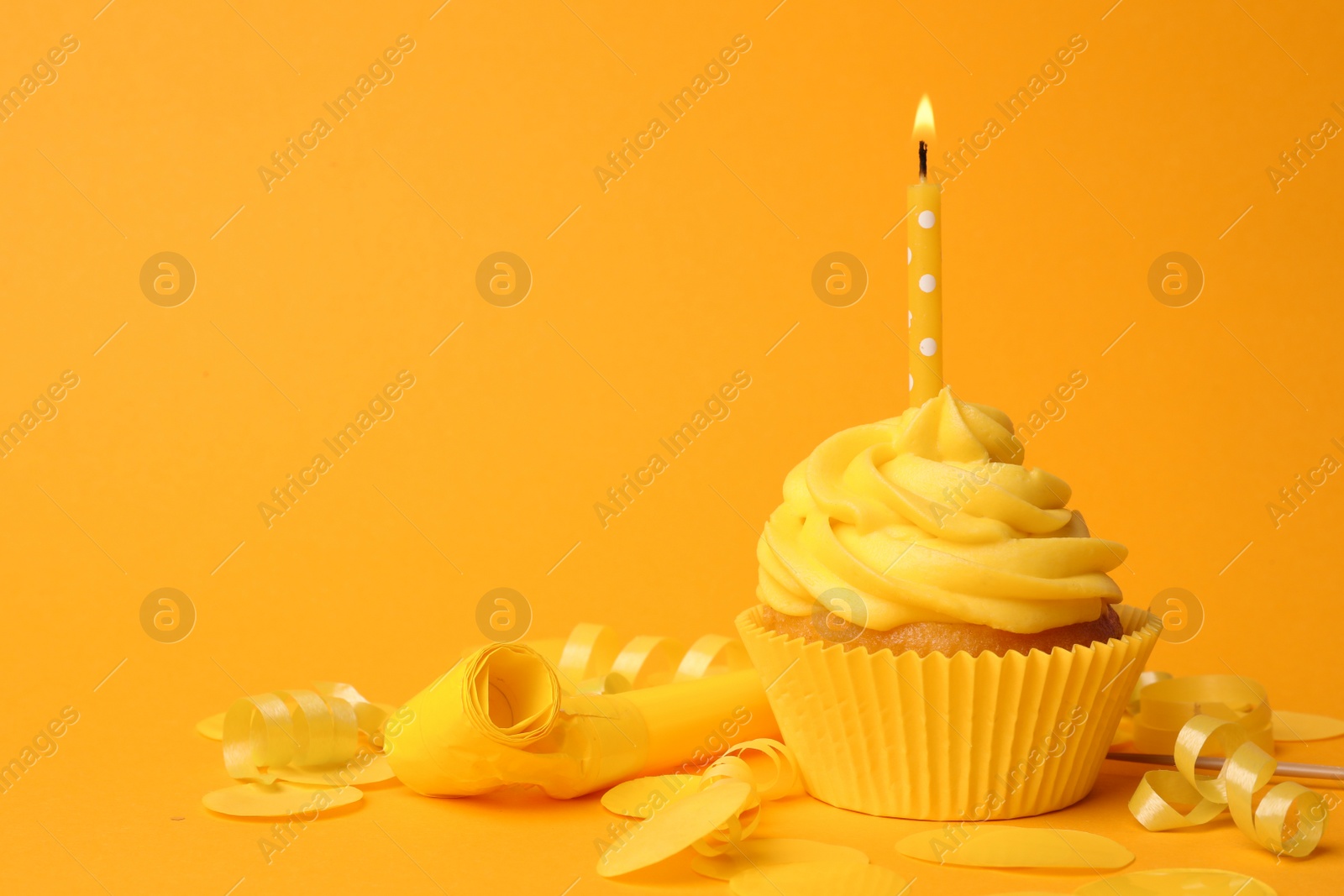 Photo of Delicious birthday cupcake with cream and burning candle on yellow background. Space for text