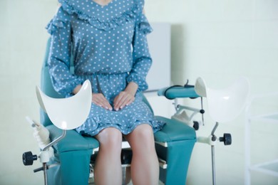 Photo of Gynecological checkup. Woman sitting on examination chair in hospital, selective focus