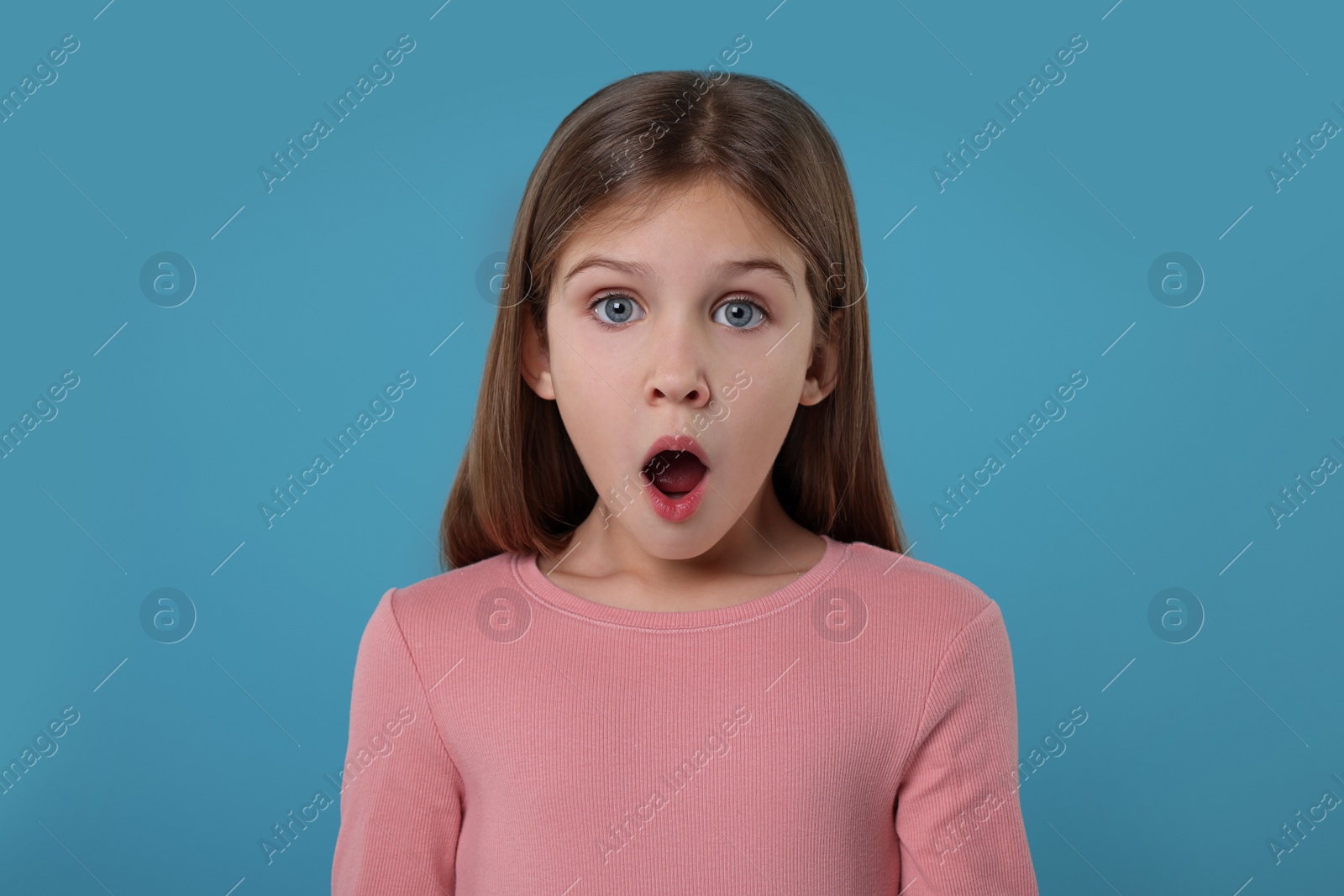 Photo of Portrait of surprised girl on light blue background