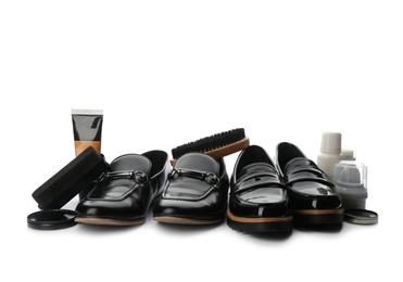 Stylish footwear and shoe care products on white background