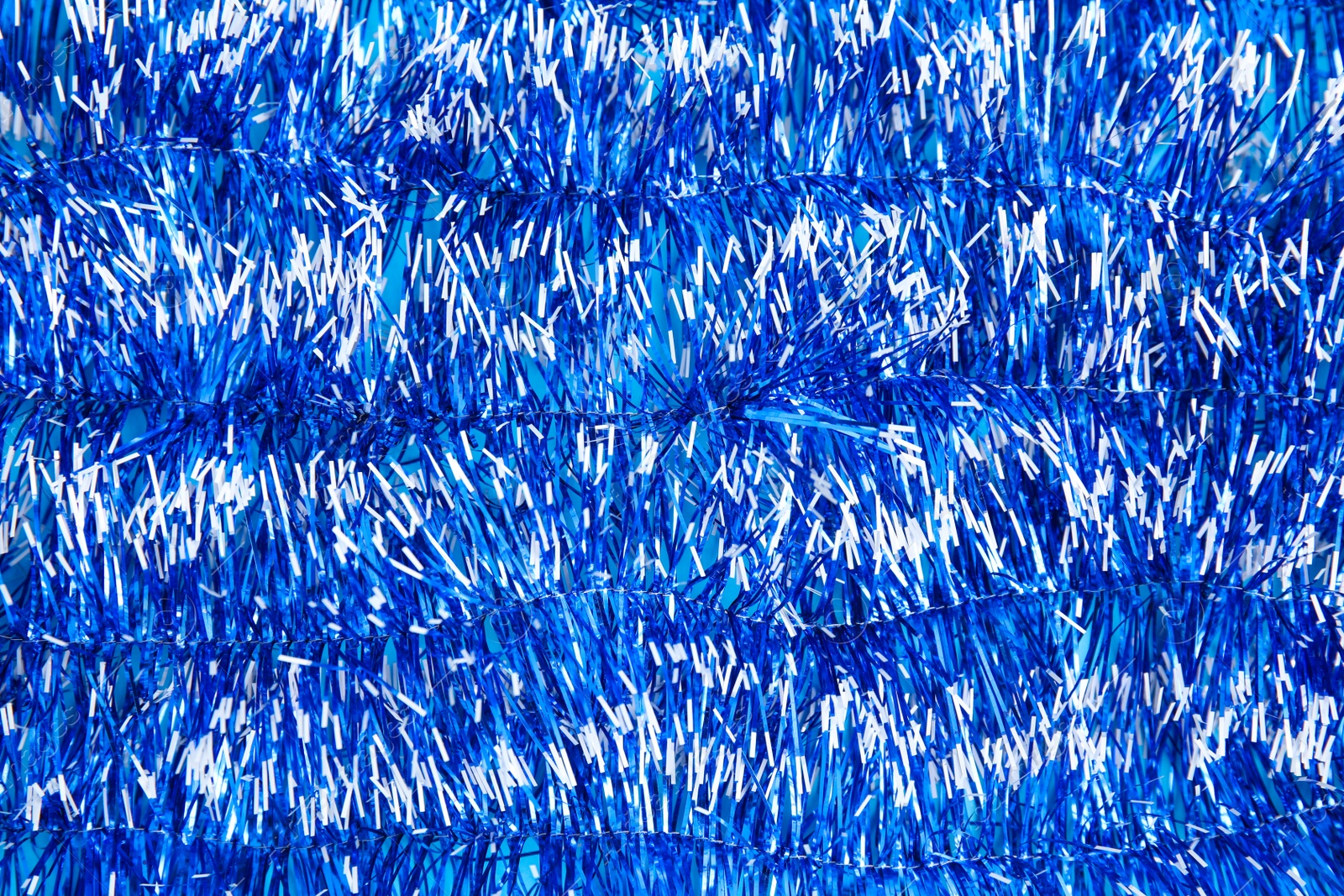 Photo of Bright blue tinsel as background. Festive decoration
